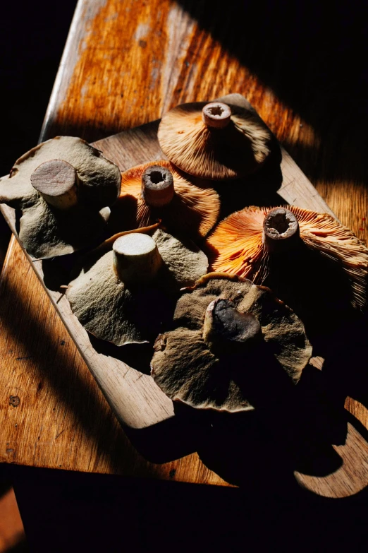 a tray of mushrooms on top of a wooden table