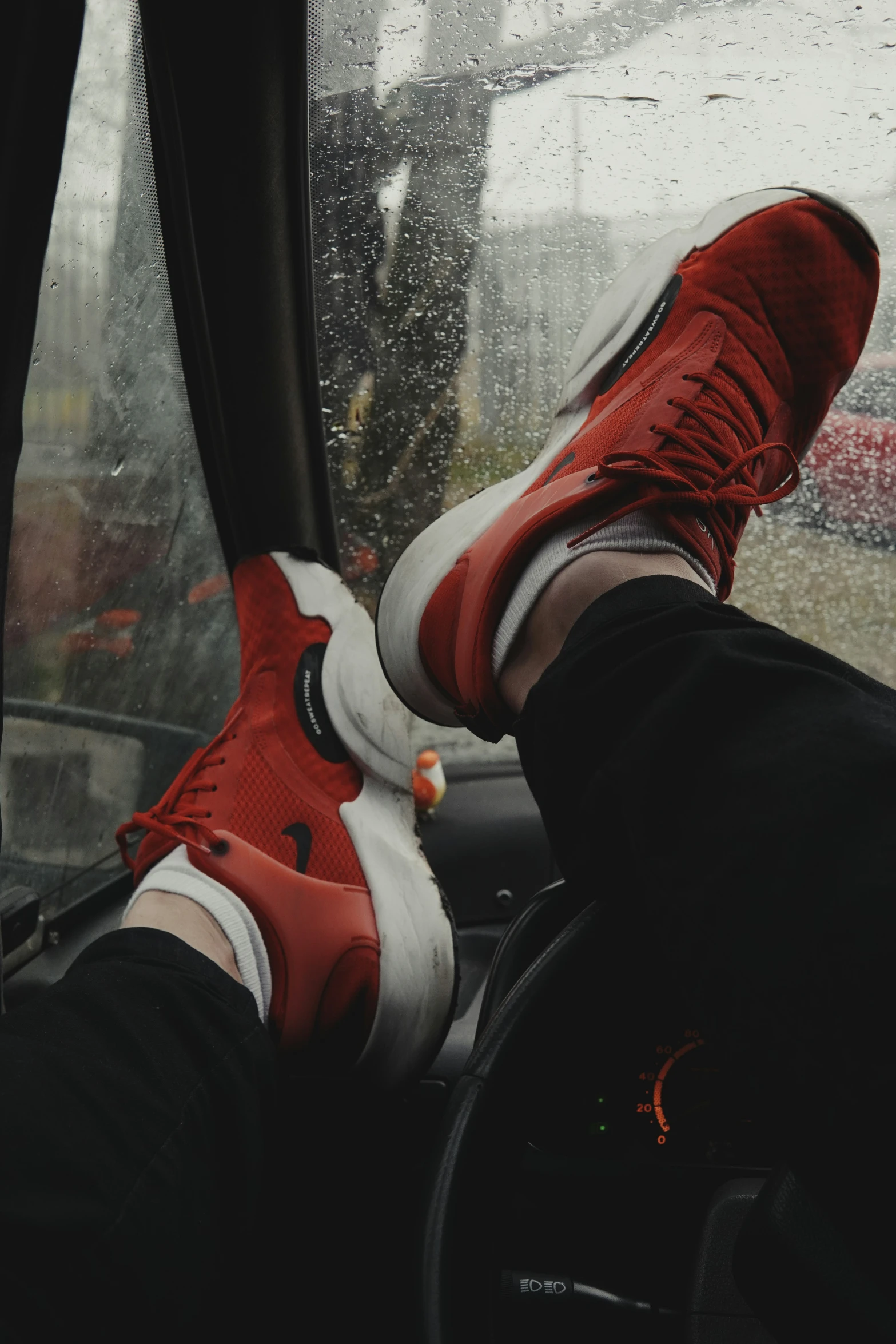 person sitting on the seat of an auto vehicle while they're on a rainy day