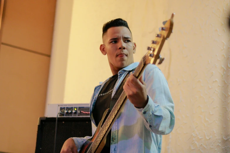 man playing guitar with sound equipment in background