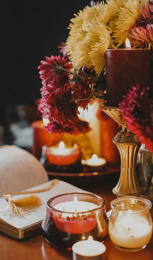 a table with three small lit candles and two books