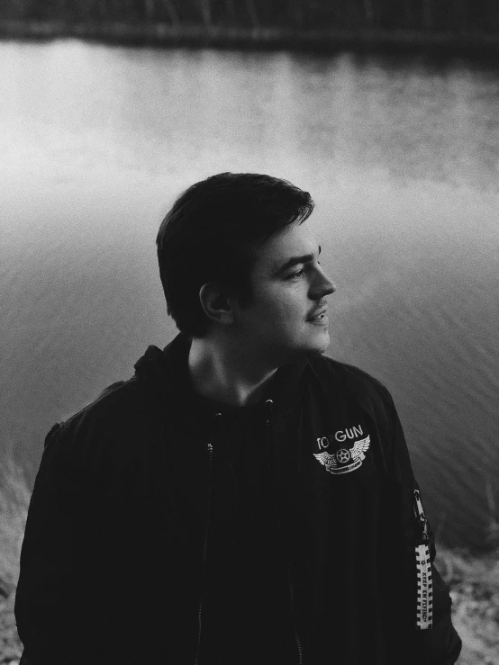 black and white image of young man near water