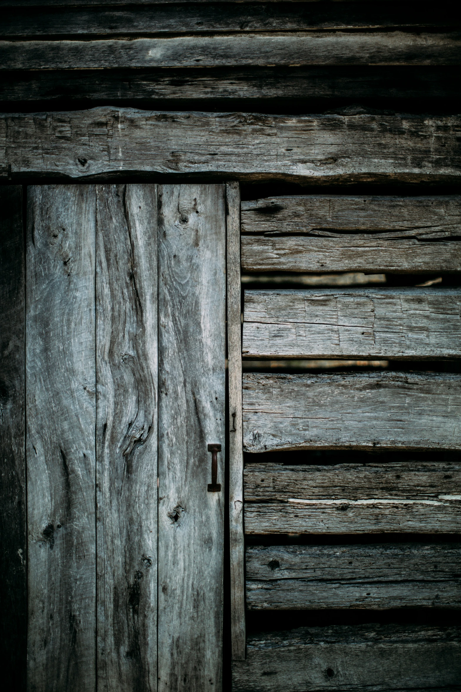 an old door is closed to the wooden structure