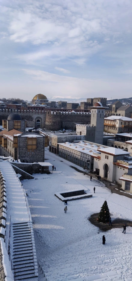 view of snowy old buildings and some people walking