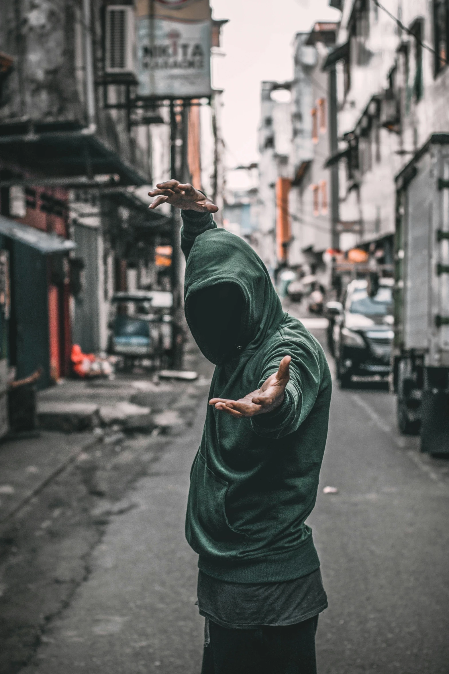 man with a green hoodie on holding a bird on his arm