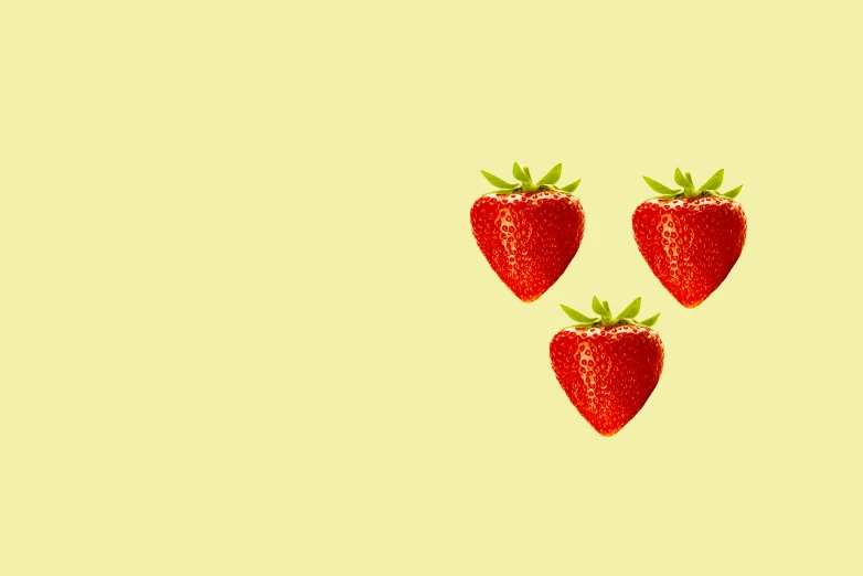a close up of three strawberries on a table