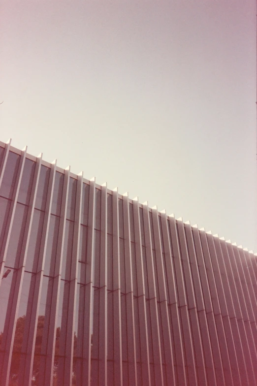 a view up into the sky shows a building made of tall glass blocks