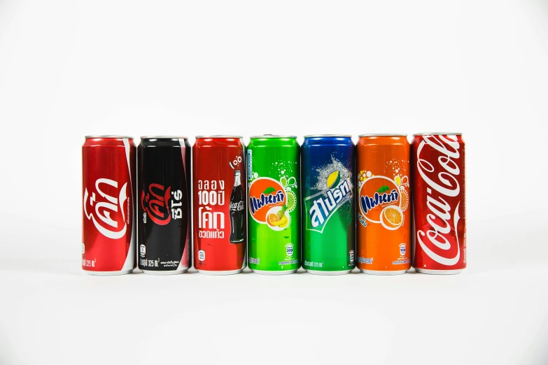 six cans of soda are lined up in a row