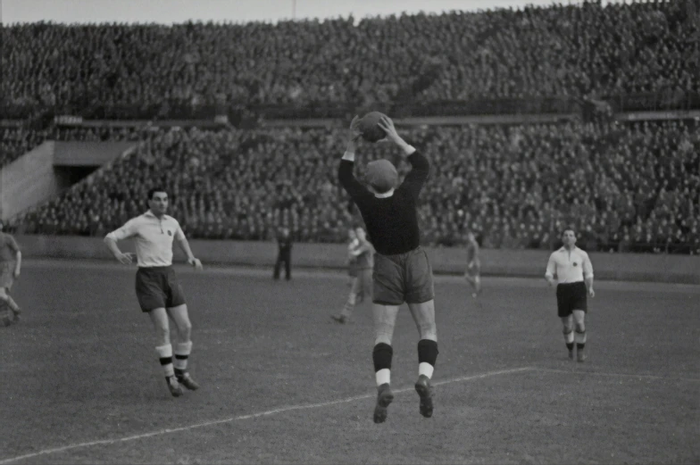 a black and white po of a person jumping up in the air to get a ball