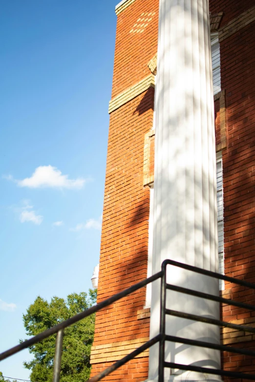 some white pillars against a brick building and sky