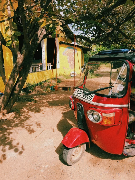 a red moped sits parked in a driveway