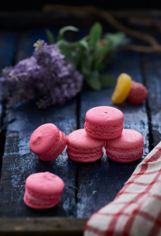 pink and yellow cookies and pink flower next to blue wood