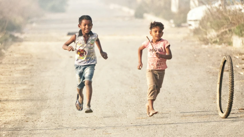 a couple of young children run across the street