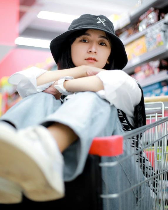  wearing hat sitting on cart in grocery store