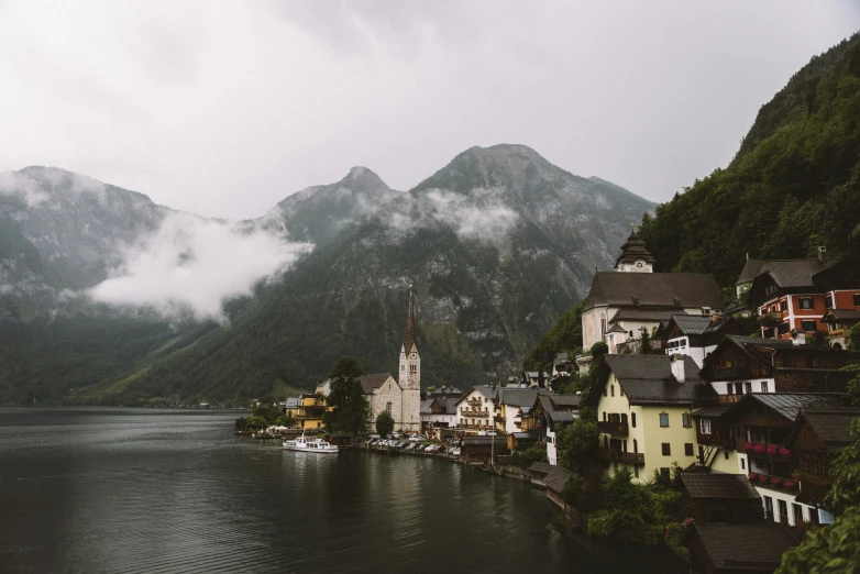 a lake with houses and mountains in the background