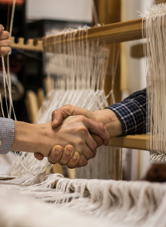 people are shaking hands across a loom