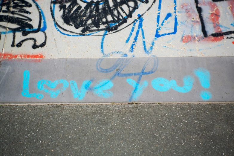 a group of graffiti sprayed on the ground near the curb