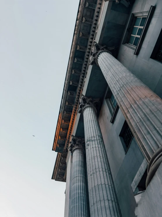 tall stone building with columns and clock on the top