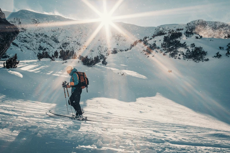 a skier that is looking up at the sun