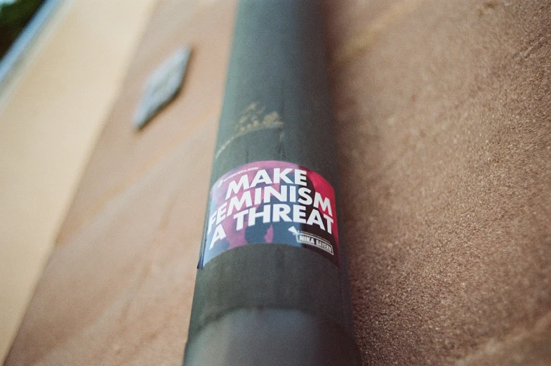 a baseball bat with a sticker that says make feminist a threat