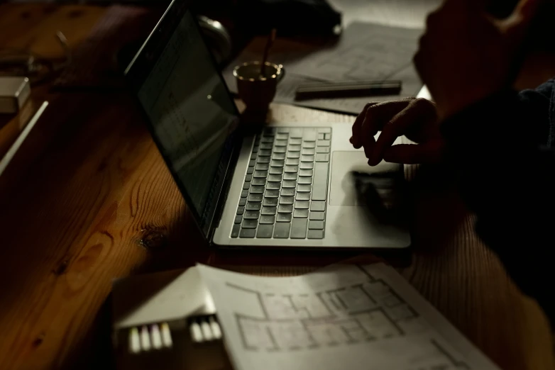 a laptop sitting on a desk surrounded by various papers