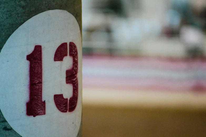 a closeup of the number thirteen painted on a sign