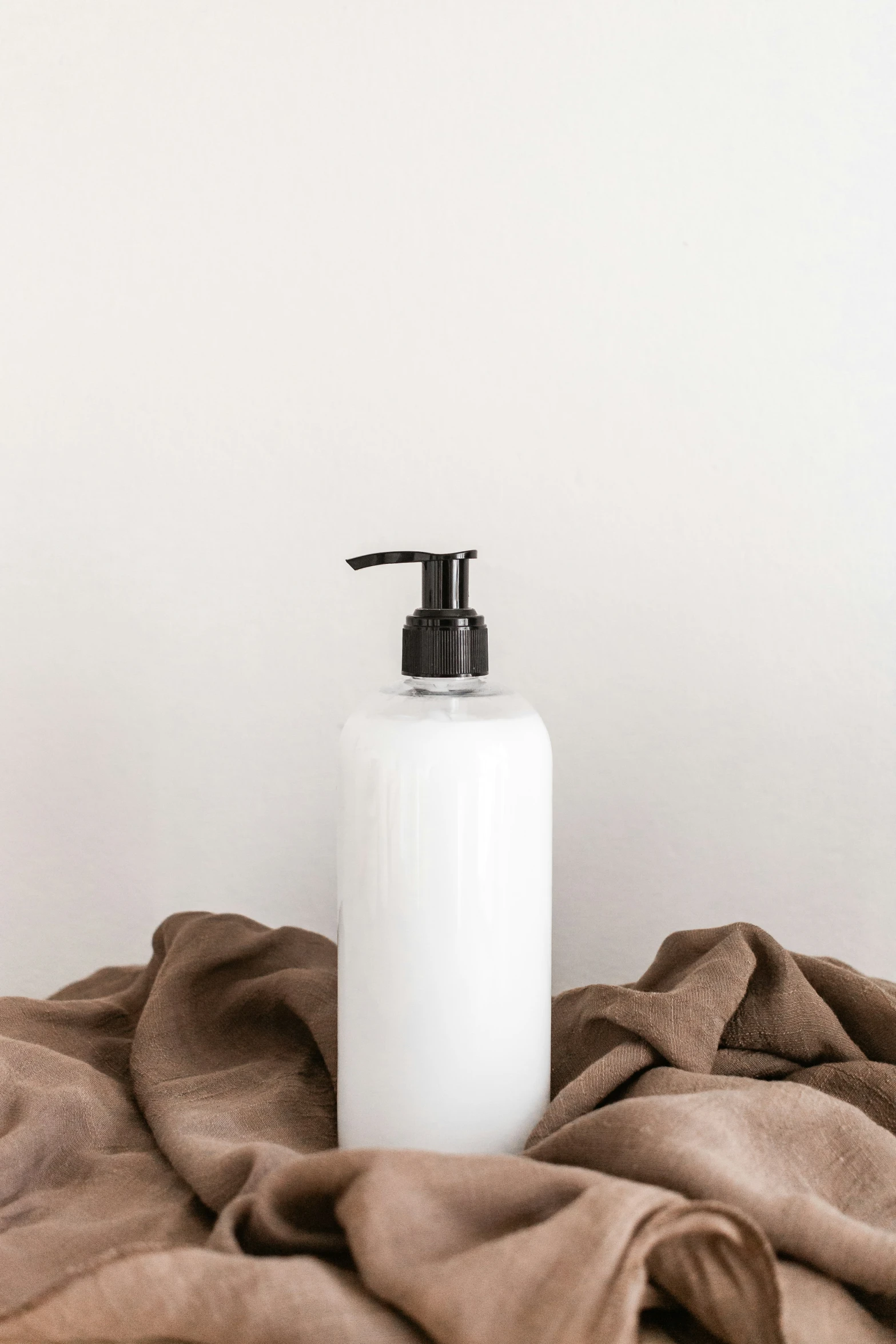 a soap dispenser on top of a blanket