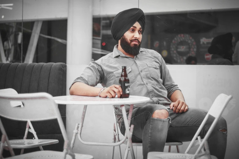 a man is sitting at a table with a bottle