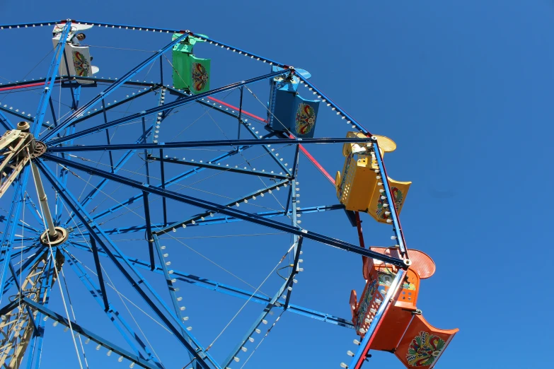 the ferris wheel is close to a bright blue sky