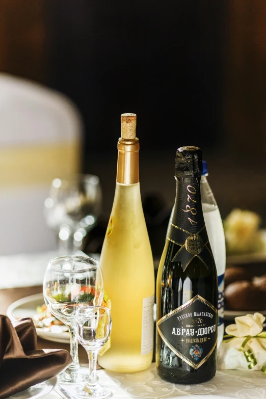 a table with two wine bottles and glasses on it