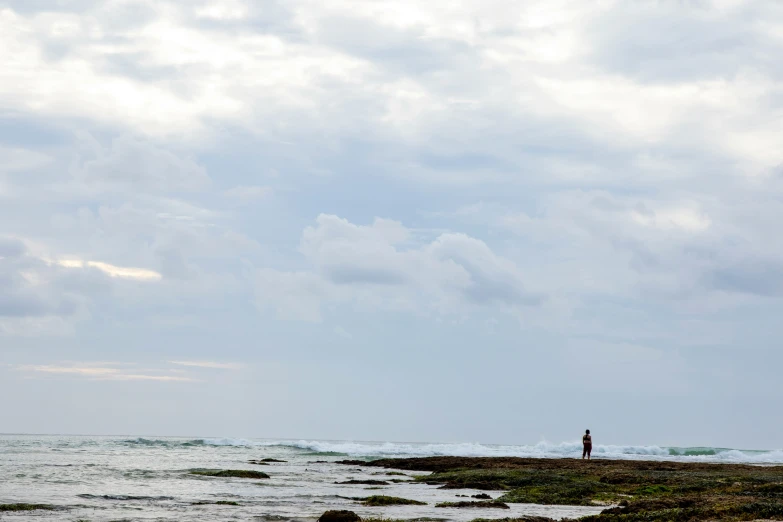 a man standing on the beach watching the ocean