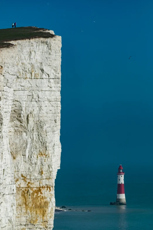 a lighthouse that is next to a large cliff