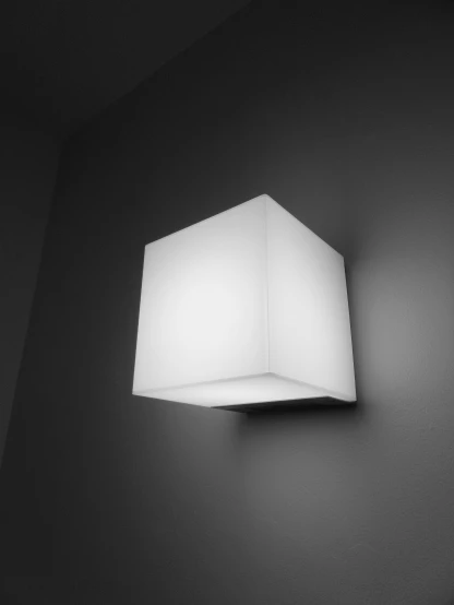 an square wall light mounted to the side of a black wall