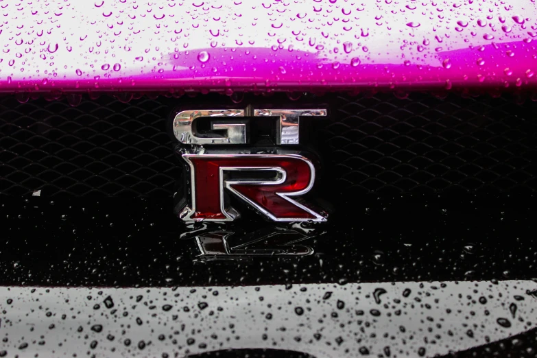 a black car with red lettering is surrounded by raindrops