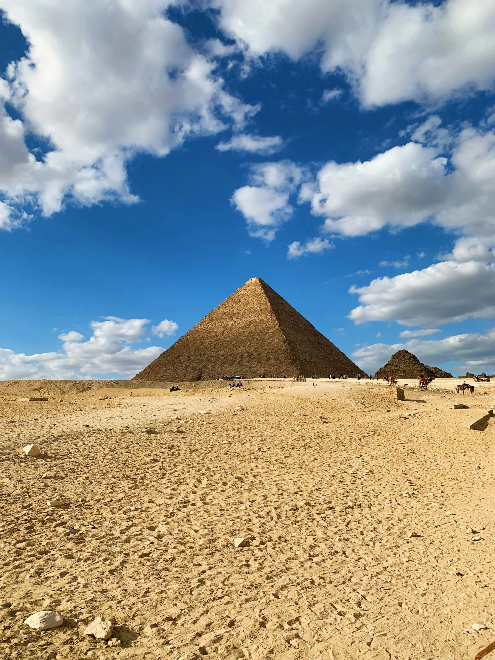 three pyramids under a cloudy blue sky