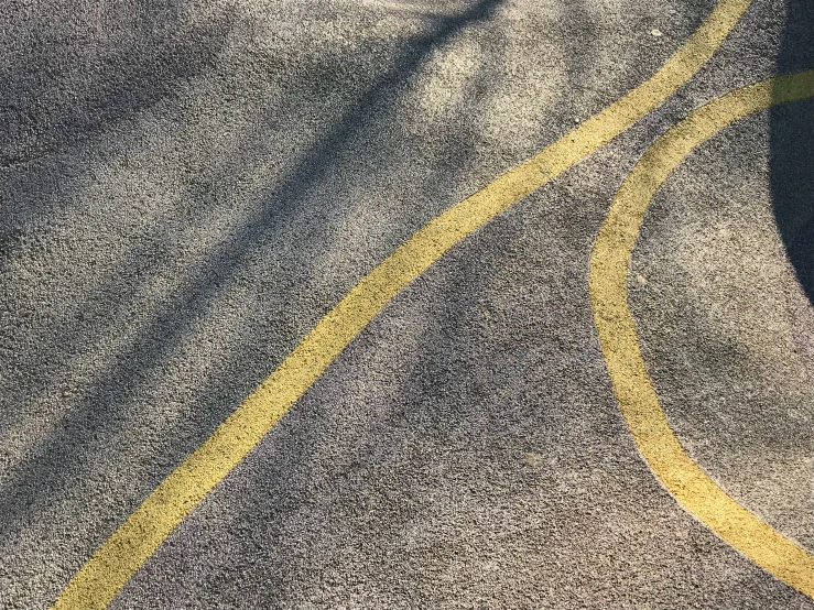 the yellow stripe of the asphalt makes it look like they are going down an incline