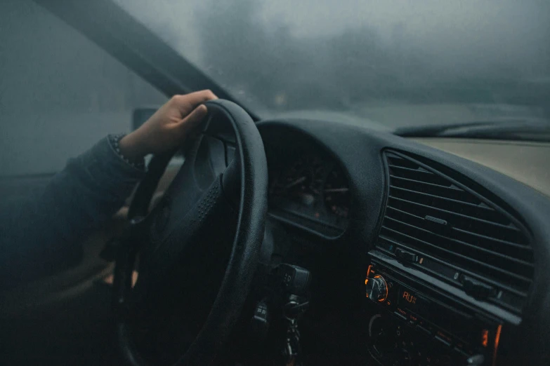 a hand holding the steering wheel handle on a car