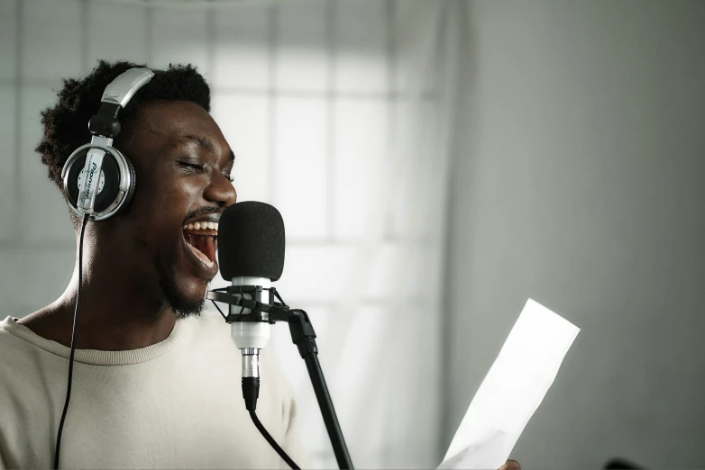 man singing into a microphone in the studio with headphones on