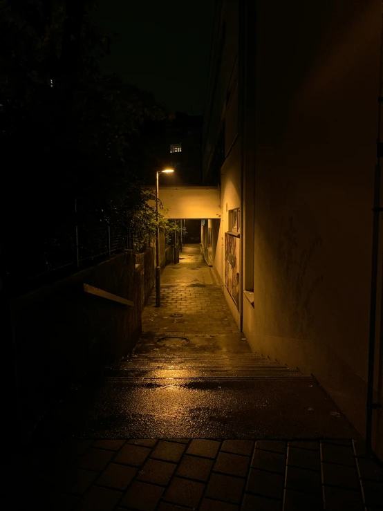 a street light shining in the dark near an alley way
