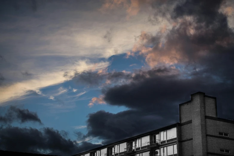 dark clouds in the sky and a building with windows