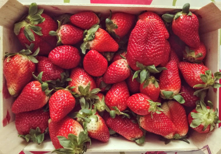 a box filled with a full bunch of strawberries