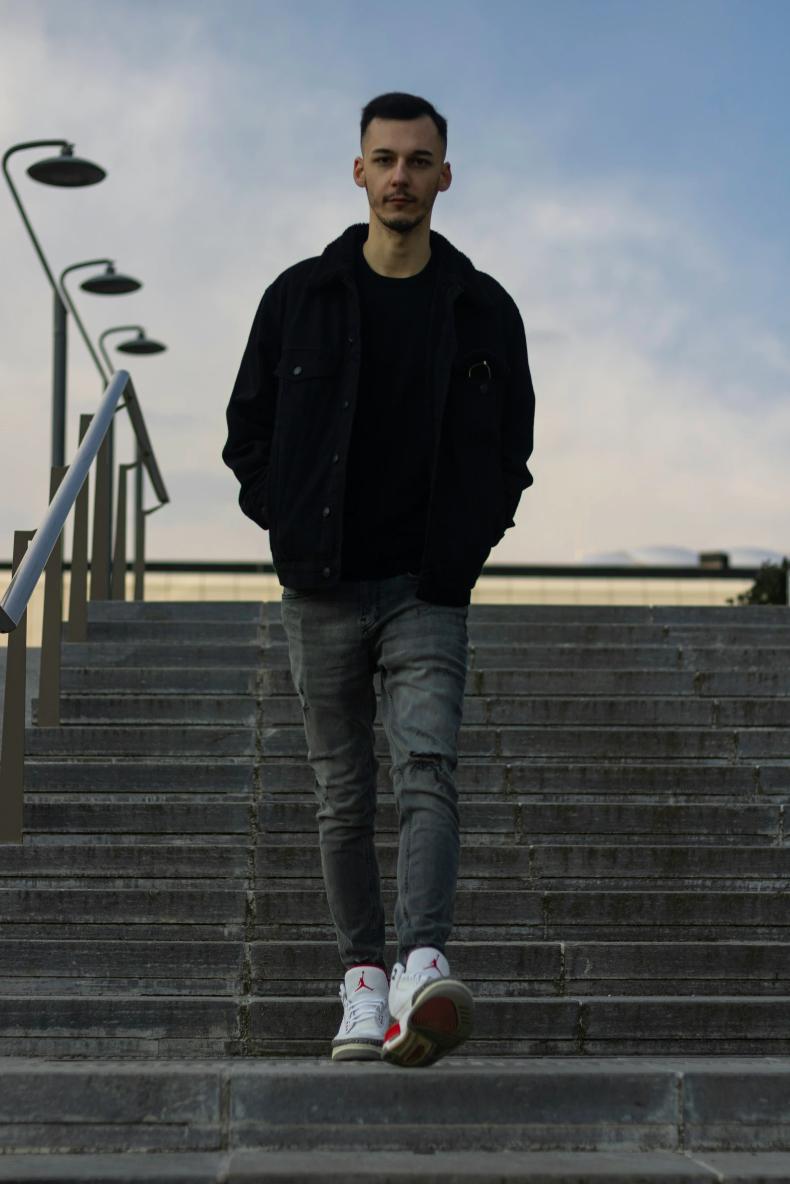 a man is standing on the stairs next to a railing