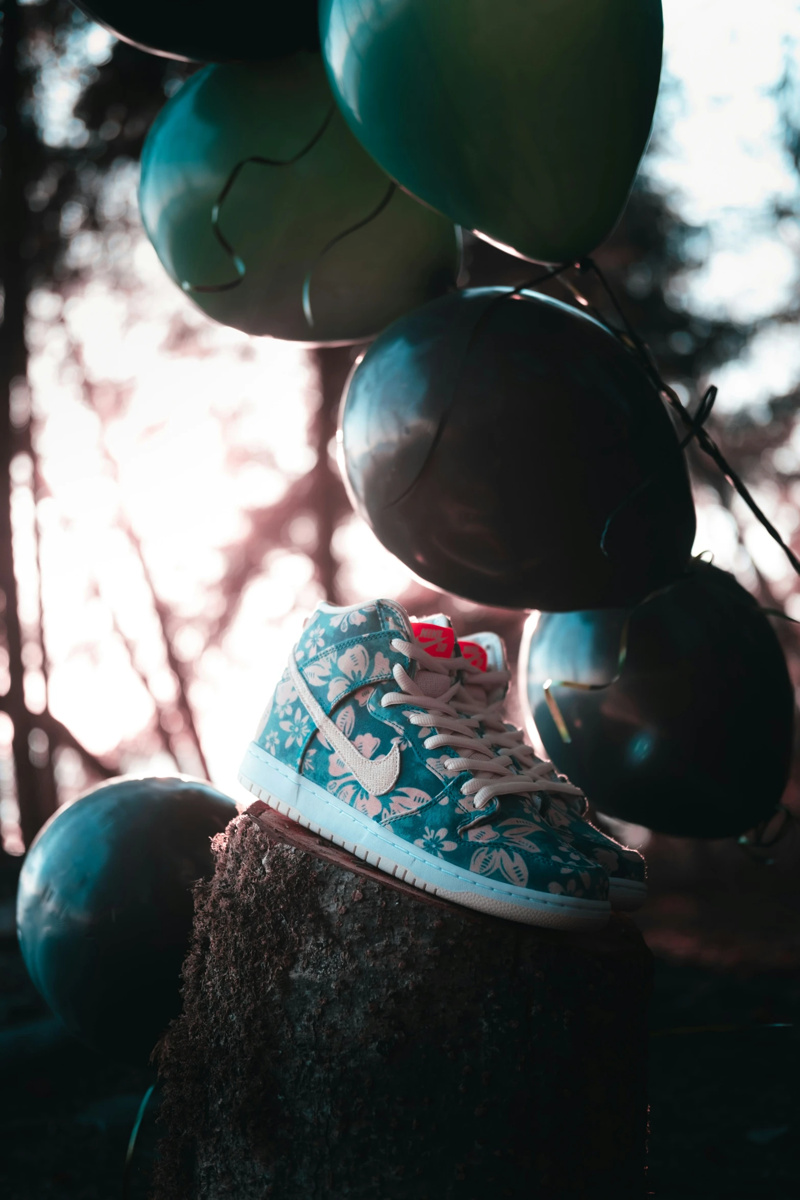 a close up view of a sneaker with balloons floating around