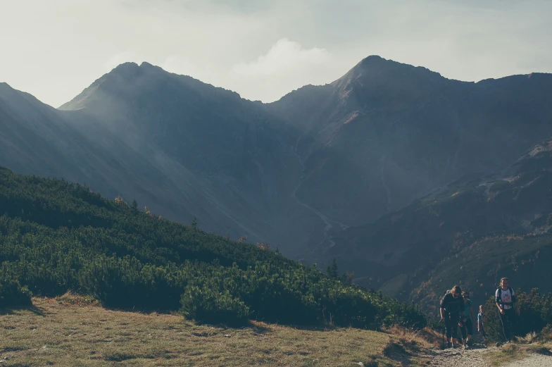 people on a mountain top with grass and rocks