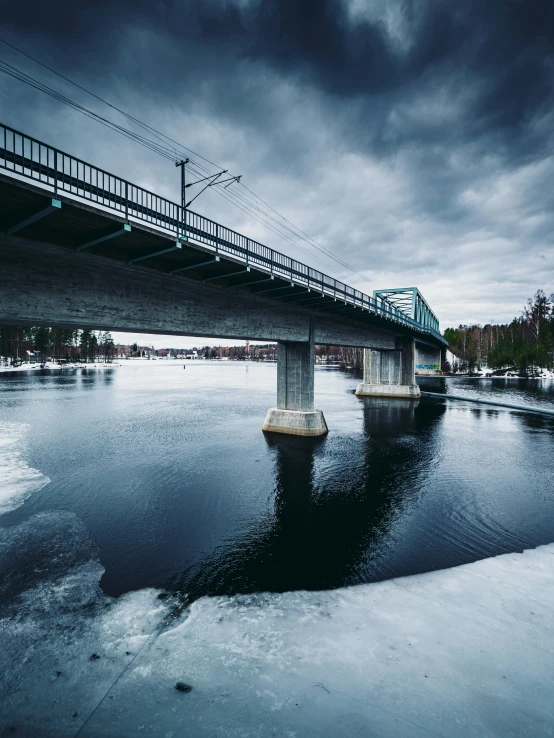 the bridge is empty on the water near a large bridge