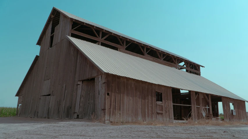 an old barn is out in the grass