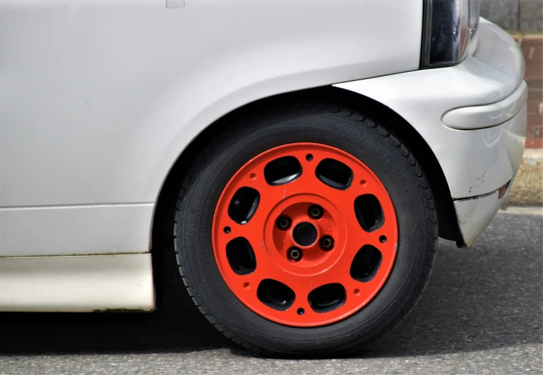 the rear tire of a car with a red hub