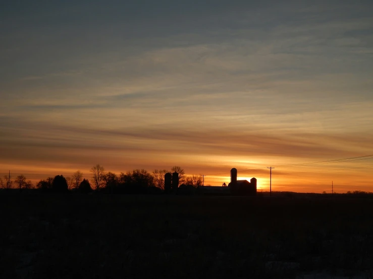 an empty field in the evening with buildings in the distance