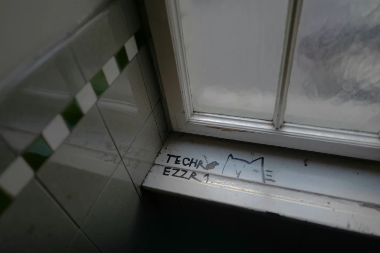 a graffiti writing on the wall underneath a window