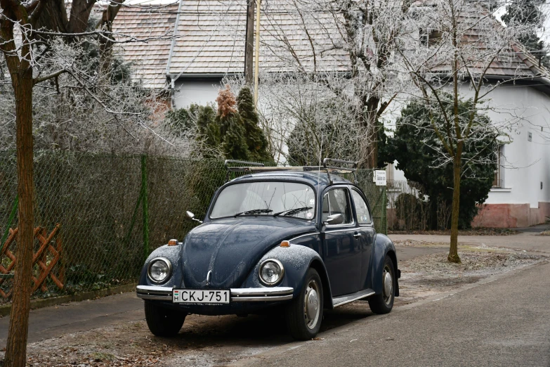 a small blue car sitting in the street