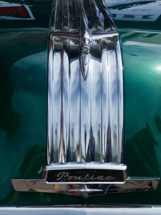 an old classic car with its shiny metal hood ornament